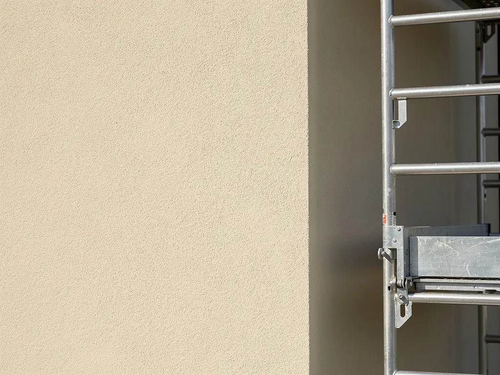 Mur de maison fini à l'enduit minéral taloché après une isolation par l'extérieur